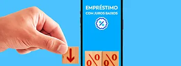 Uma mão segurando uma placa com uma seta apontando para baixo ao lado de um celular na tela de emprestimos com dois blocos iguais ao que a mão está segurando com um símbolo de porcentagem em cada uma.